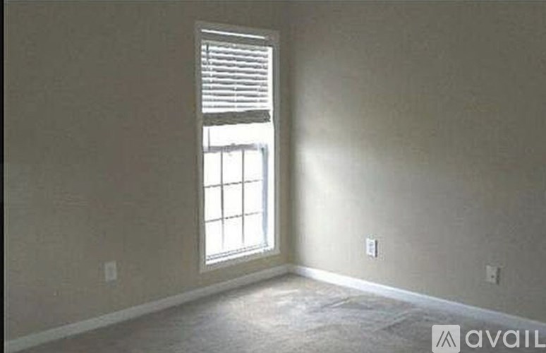 A room with a window and a wall socket.