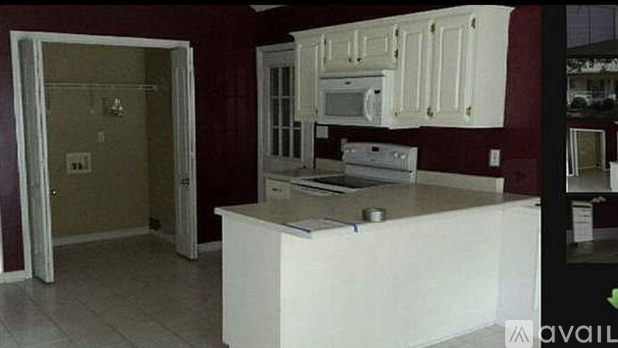 A kitchen with white cabinets and appliances is available for rent.