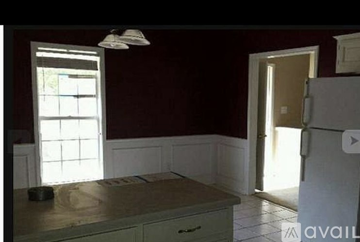 A kitchen with a window and a refrigerator.