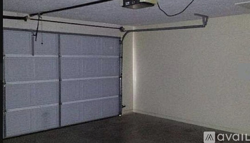 A garage door is closed and the wall is white.