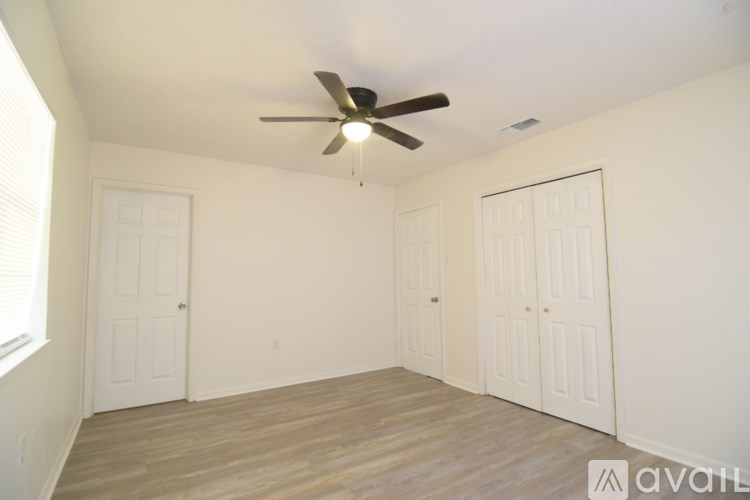 A room with a ceiling fan and wooden flooring.