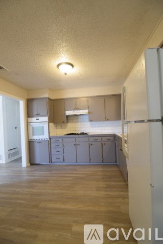 A kitchen with wooden floors and white appliances.