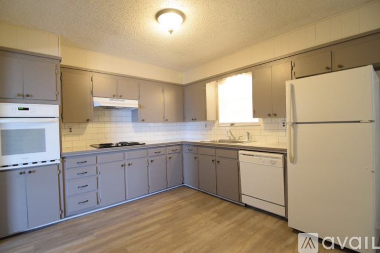 A kitchen with wooden floors and white appliances.