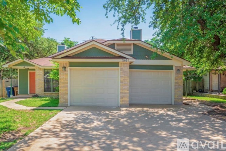 A house with a green roof and a garage door is for sale.
