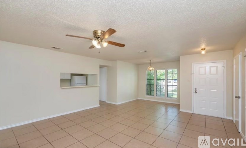 A spacious room with a ceiling fan and tiled floor.