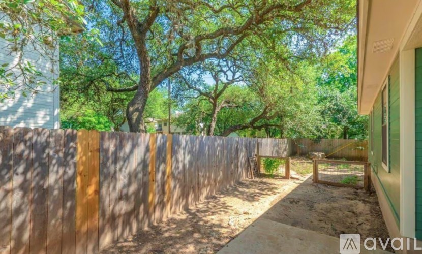 A backyard with a wooden fence and trees.