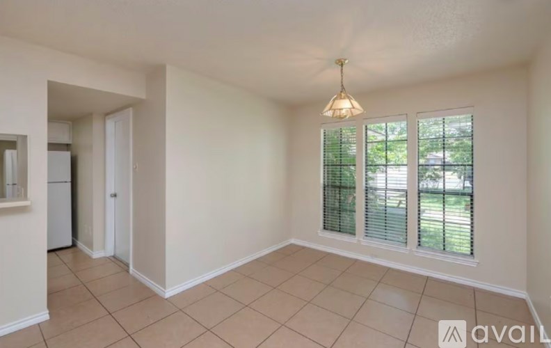 A room with a window and a hanging light fixture.