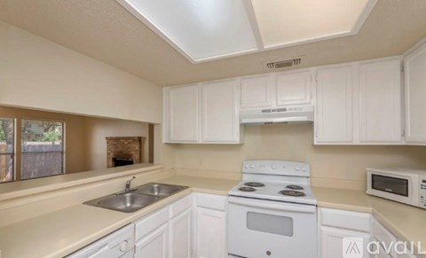 A kitchen with white cabinets and appliances.