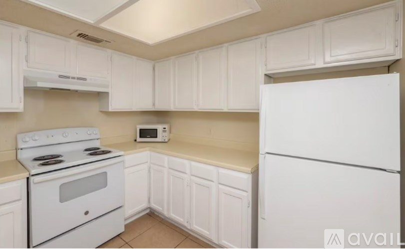 A kitchen with white appliances and cabinets.