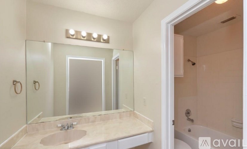 A bathroom with a sink, mirror, and shower.