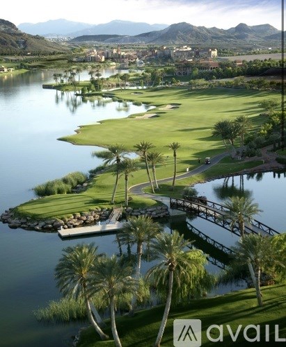 A golf course with a bridge and palm trees.