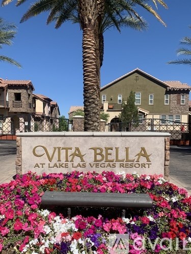 A sign for Vita Bella at Lake Las Vegas Resort sits in front of a flower bed.