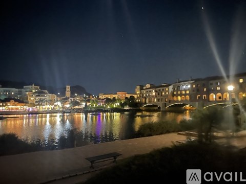 A nighttime view of a cityscape with lights reflecting on the water.