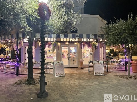 A restaurant with purple lighting and outdoor seating.
