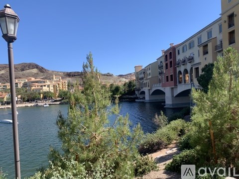 A street lamp stands on the left side of a river with buildings on the right.