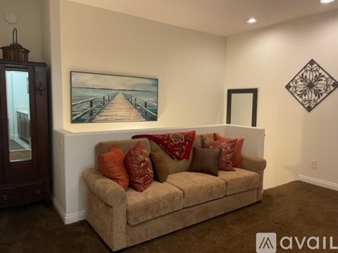 A living room with a couch, a painting, and a cabinet.