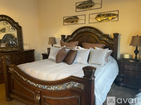 A bed with a white comforter and brown pillows is in the image.