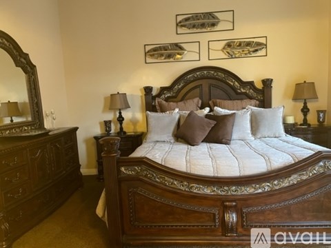 A bedroom with a large bed and a wooden dresser.