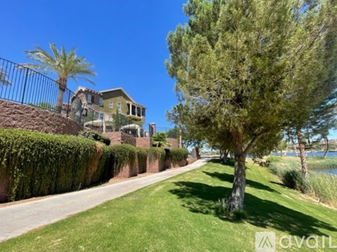 A tree stands on a lawn in front of a house.