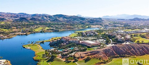 A bird's eye view of a lake surrounded by greenery and mountains.