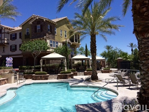 A pool surrounded by palm trees and chairs.