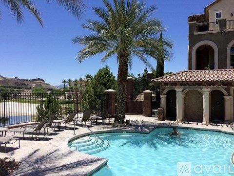 A pool with a person in it and a palm tree in the background.