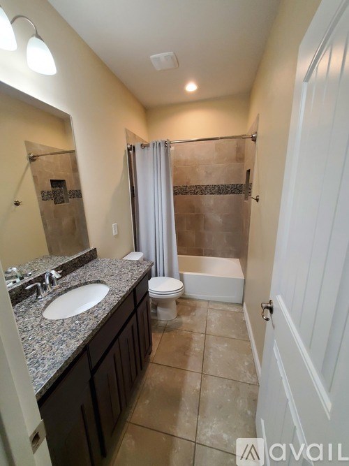 A bathroom with a sink, toilet, and shower.