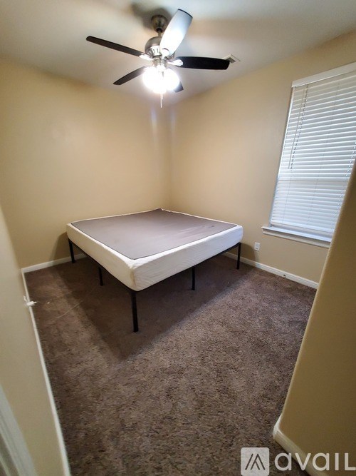 A bedroom with a bed and a ceiling fan.