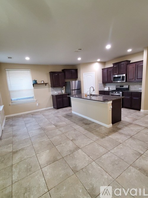 A kitchen with brown cabinets and a tiled floor.