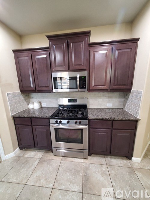 A kitchen with a stove top oven and microwave.