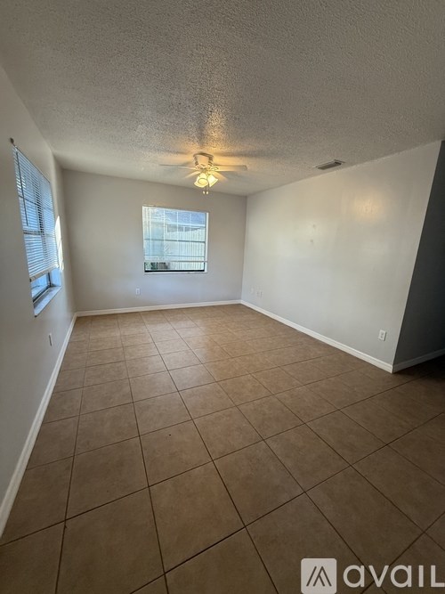 A room with tiled flooring and a window with blinds.