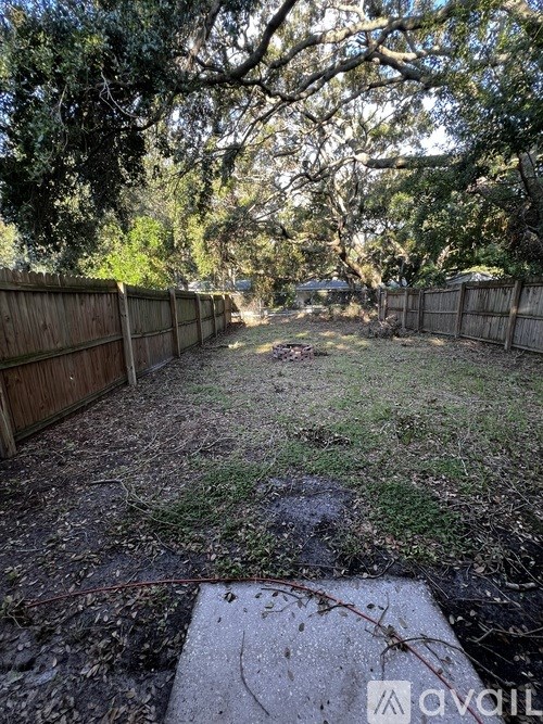 A backyard with a wooden fence and trees.