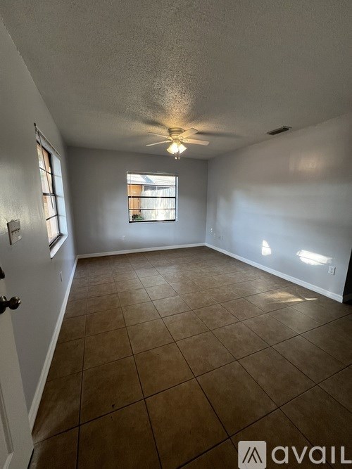 A room with a ceiling fan and tiled floor.