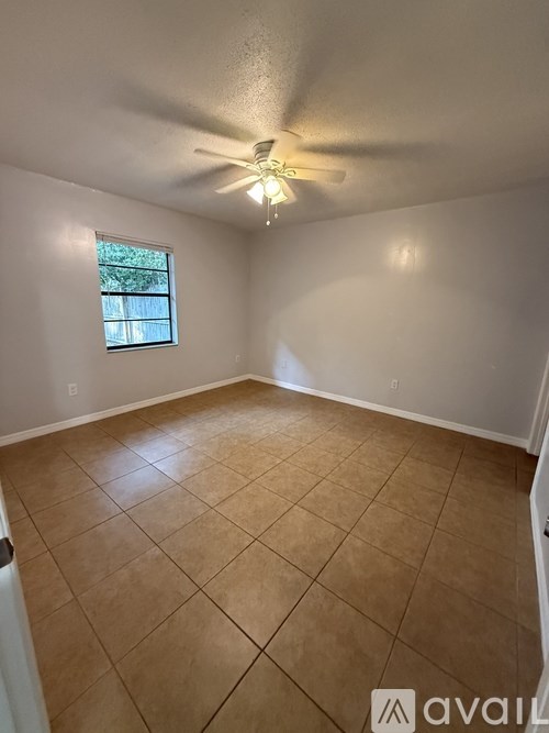 Empty room with a ceiling fan and a window.