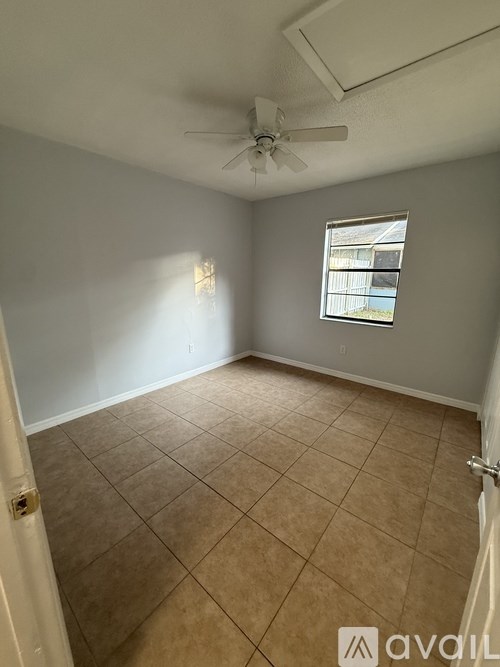 A room with a ceiling fan and a window.