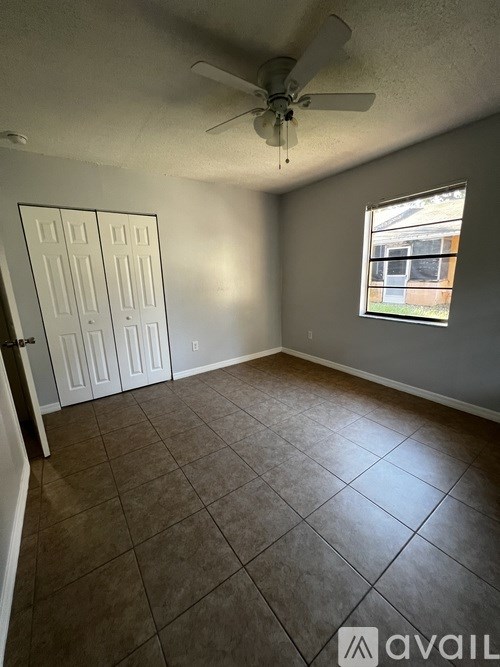 A room with a ceiling fan and a window.