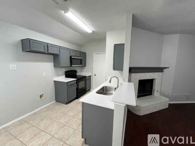 A kitchen with a white countertop and a microwave above it.