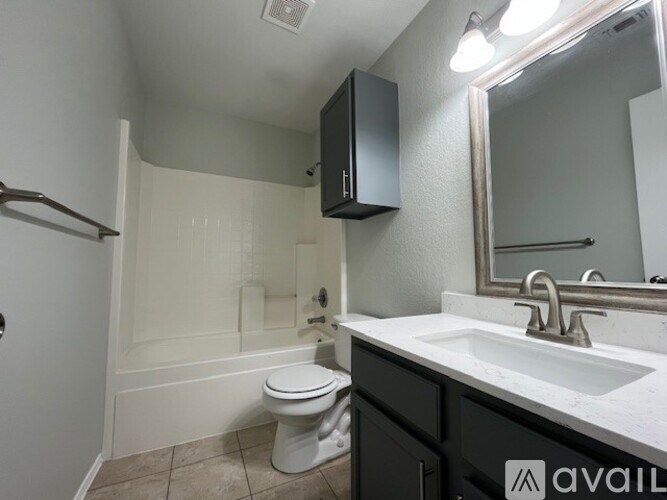A bathroom with a toilet, sink, and mirror.