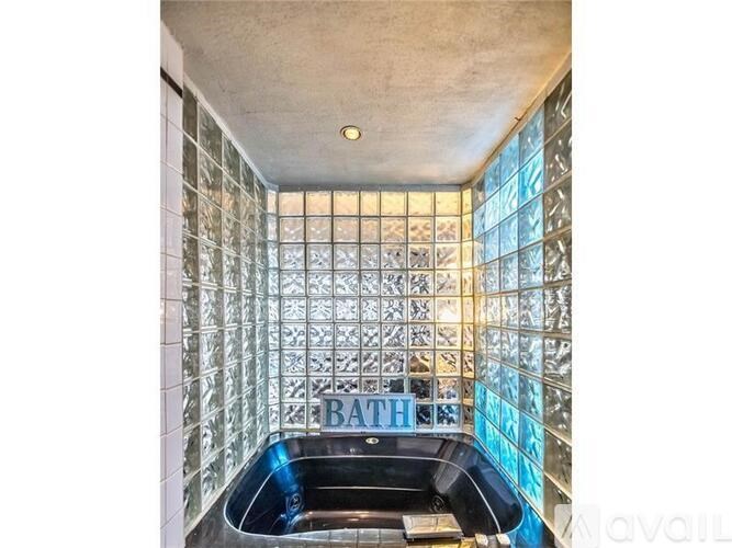 A bathroom with a tiled wall and a blue bathtub.