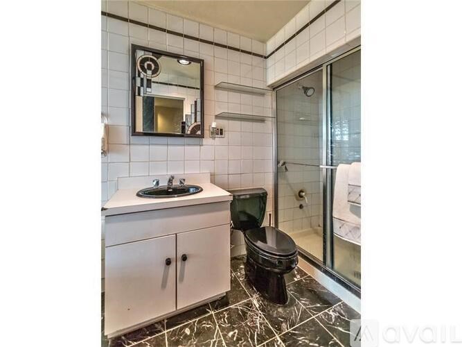 A bathroom with a sink, toilet, and mirror.