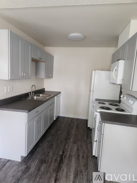 A kitchen with white cabinets and a black countertop.