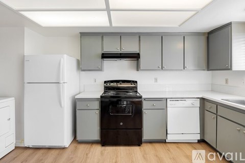 A kitchen with a white refrigerator, black stove, and white dishwasher.