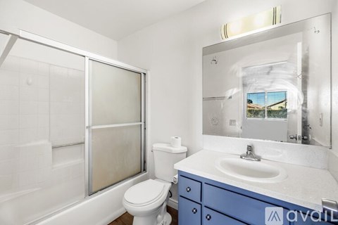 A bathroom with a white toilet, a sink, and a mirror.