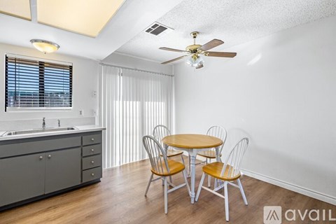 A kitchen with a table and chairs.