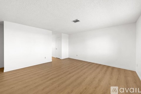 A room with wooden flooring and white walls.