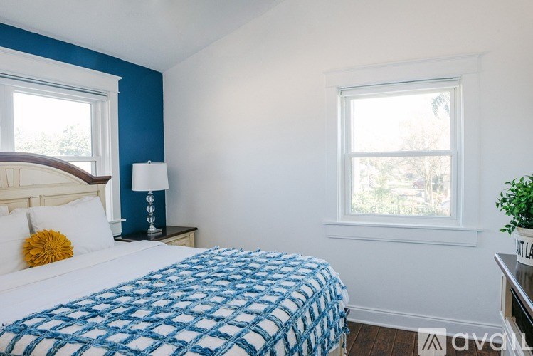 A bedroom with a bed, nightstand, and window.