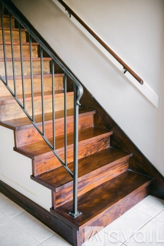 A wooden staircase with a metal railing.