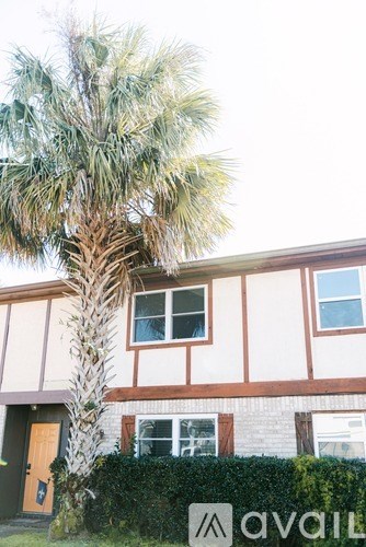 A house with a palm tree in front of it.