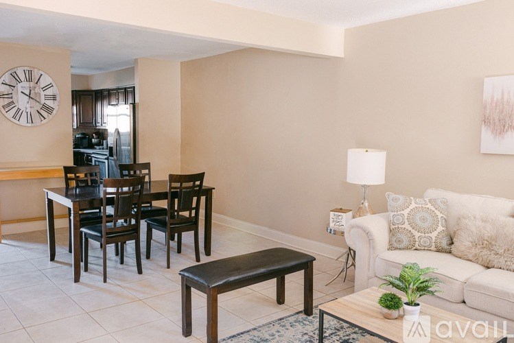 A living room with a couch, coffee table, and chairs.