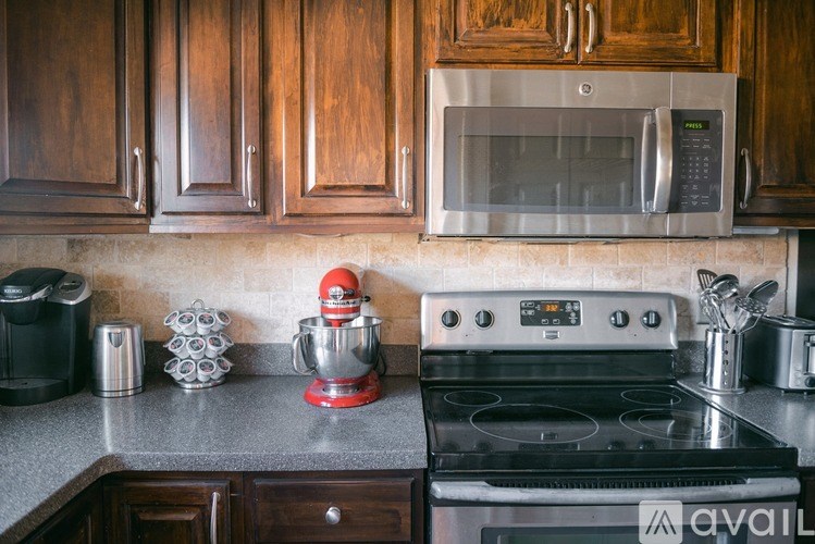 A kitchen with a red mixer and a black oven.